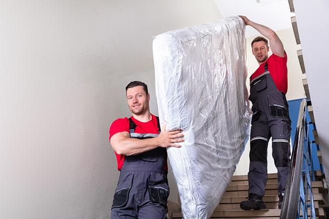 a box spring being taken out of a room during a move in Flinton